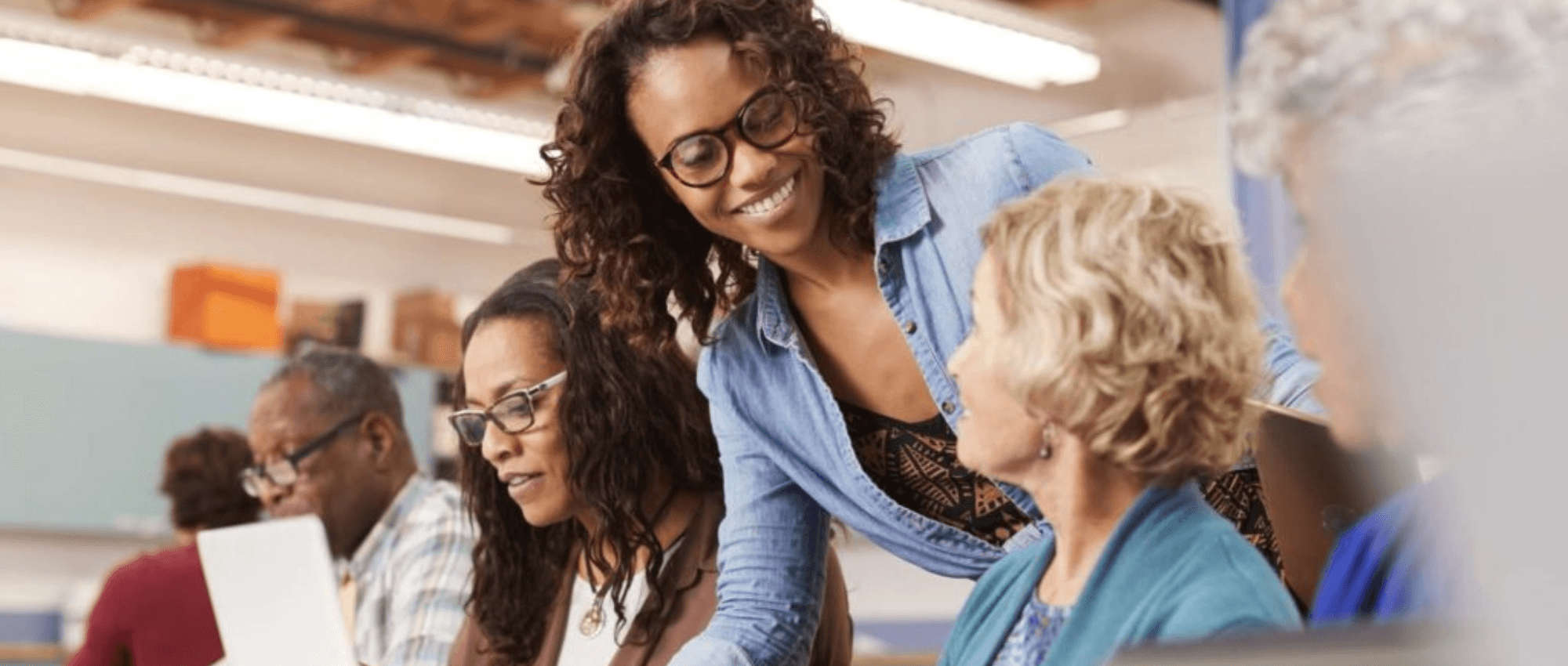 woman helping seniors with computers