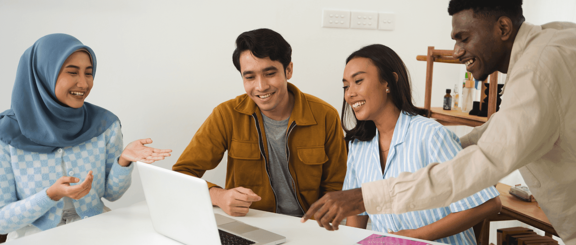 A group of friends looking at the laptop