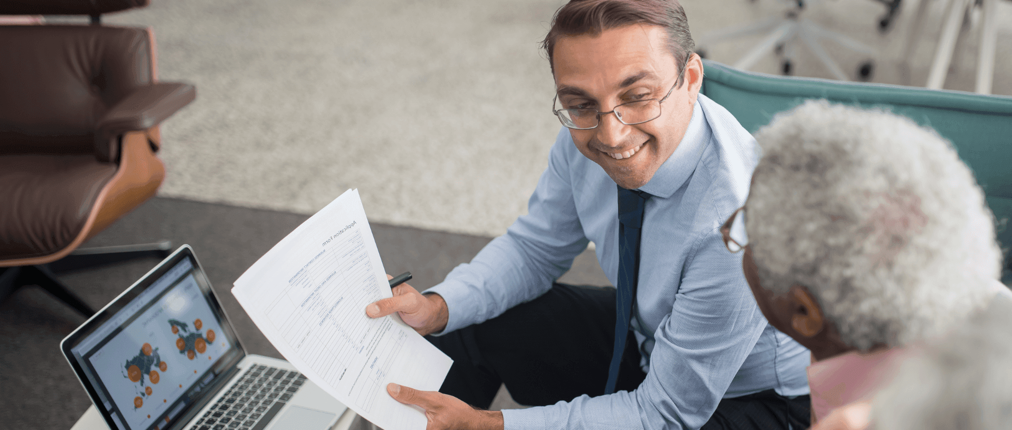A man holding papers explaining to a senior