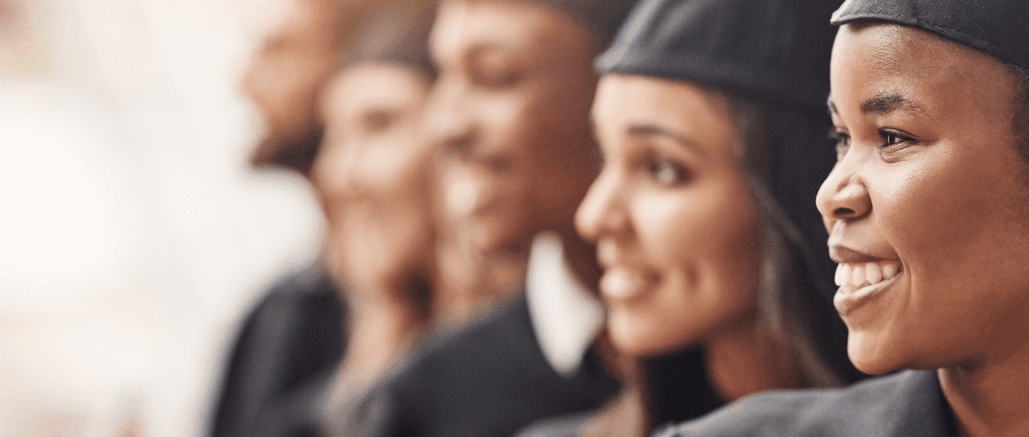 Students wearing their graduation gowns looking to the left