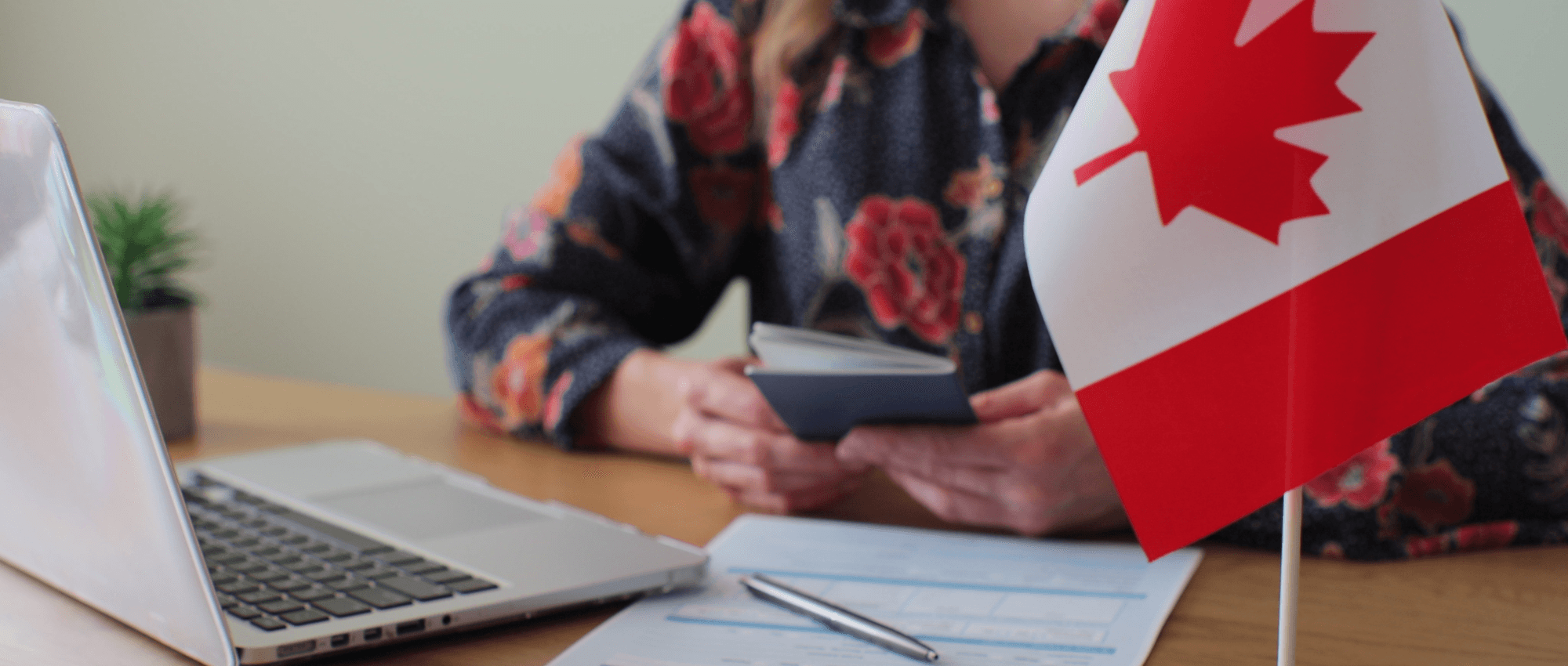 Holding-a-passport-with-the-Canadian-flag
