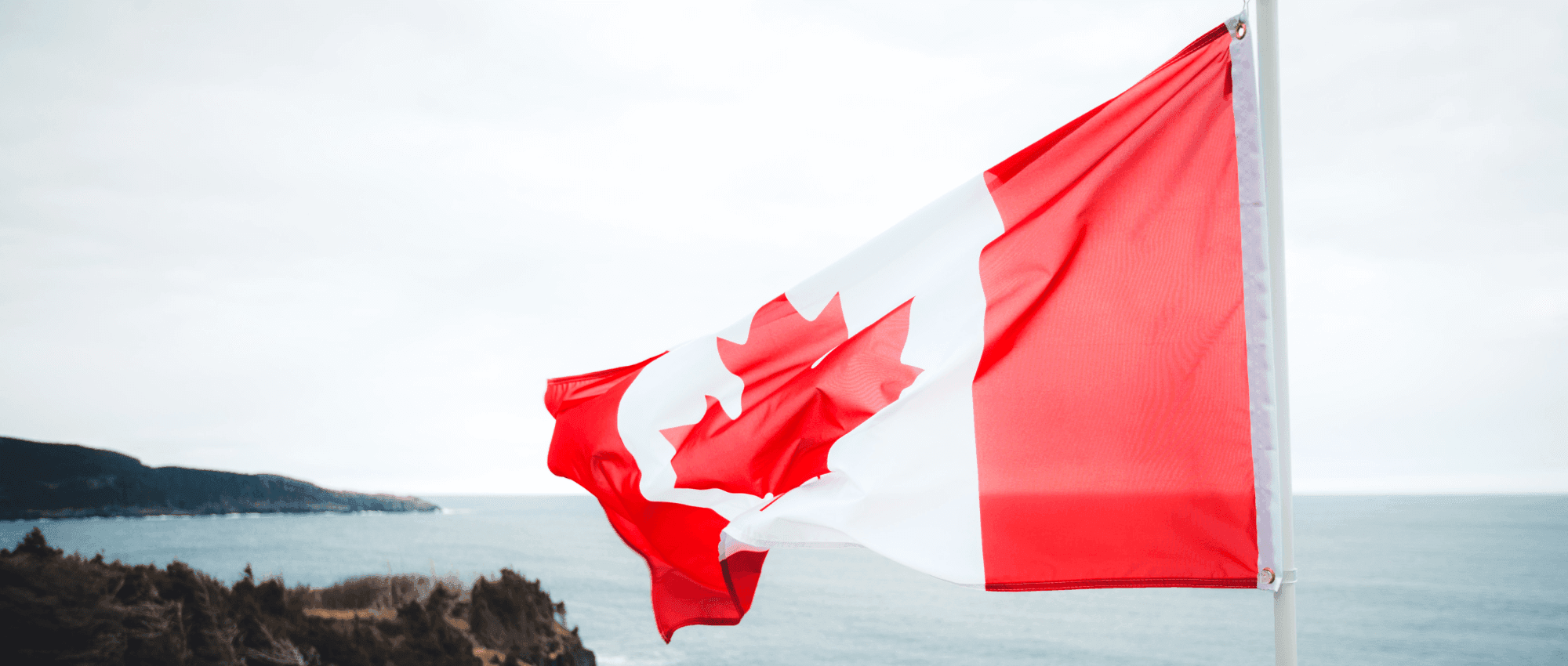 canada flag waving against shore