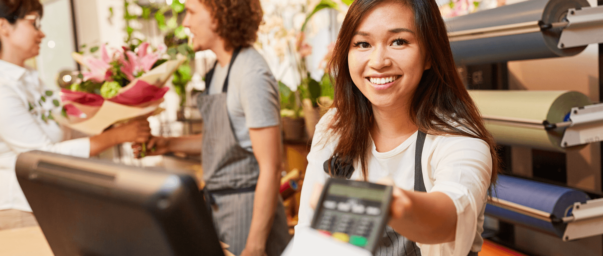 A cashier handing a card ATM scanner