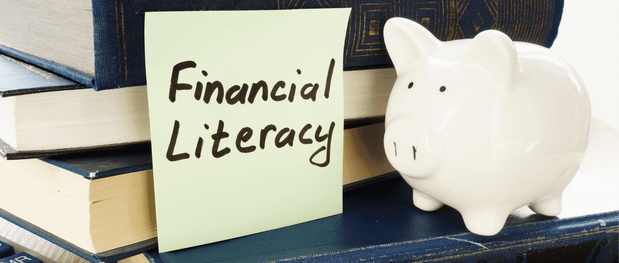 financial literacy written on sticky note with piggy bank