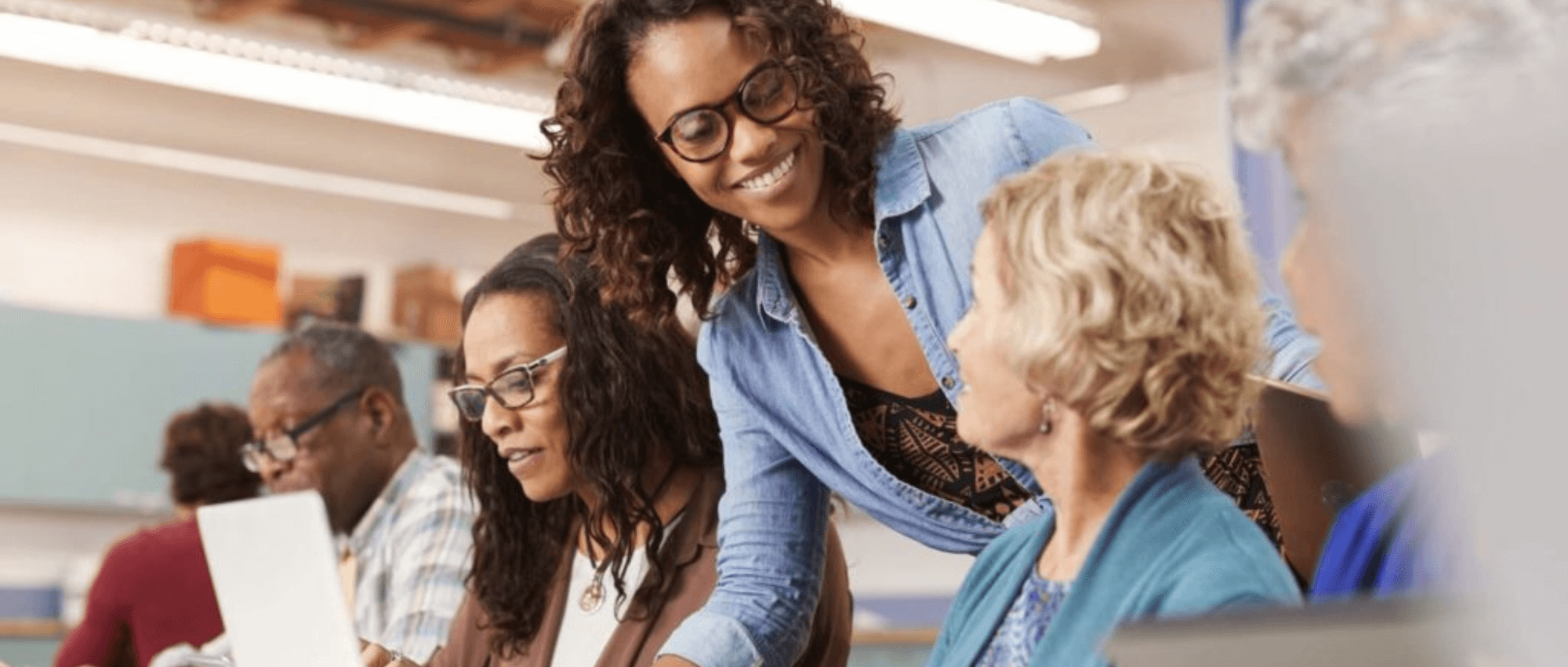 A woman helping out seniors with their use of technology